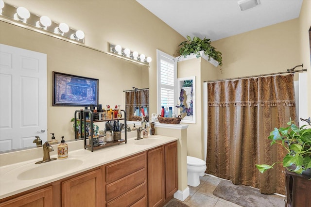 bathroom featuring a sink, visible vents, toilet, and tile patterned floors