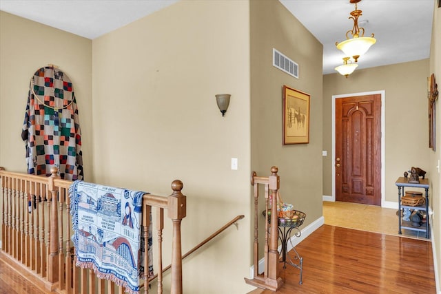 foyer with visible vents, baseboards, and wood finished floors