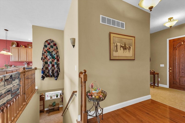 entryway featuring visible vents, baseboards, and wood finished floors