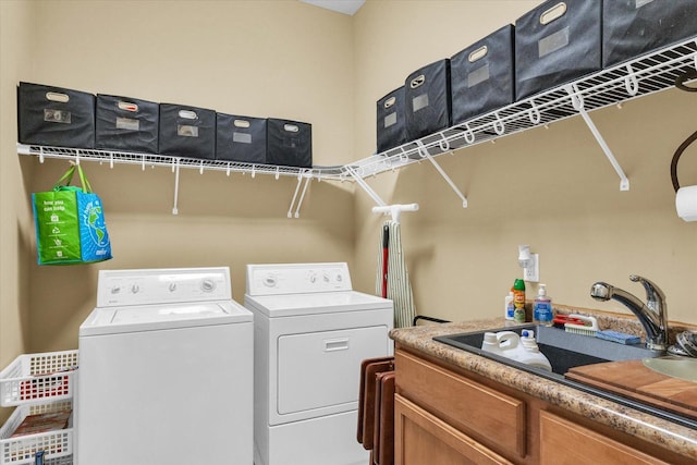 clothes washing area with cabinet space, separate washer and dryer, and a sink