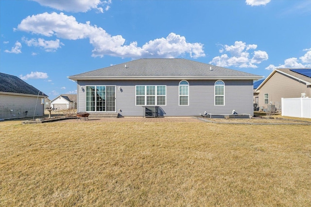 rear view of house with a yard and fence