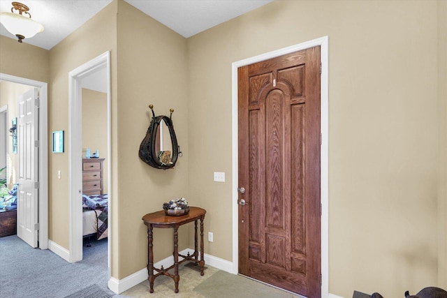 entrance foyer with light colored carpet and baseboards