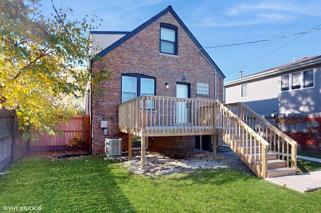 rear view of house with a lawn, central AC, and a deck