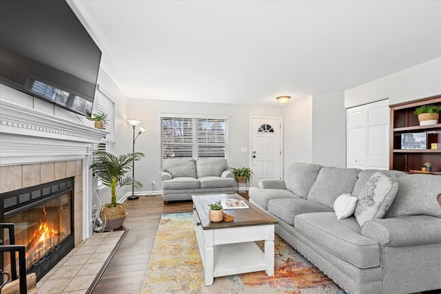 living room with hardwood / wood-style floors and a tile fireplace