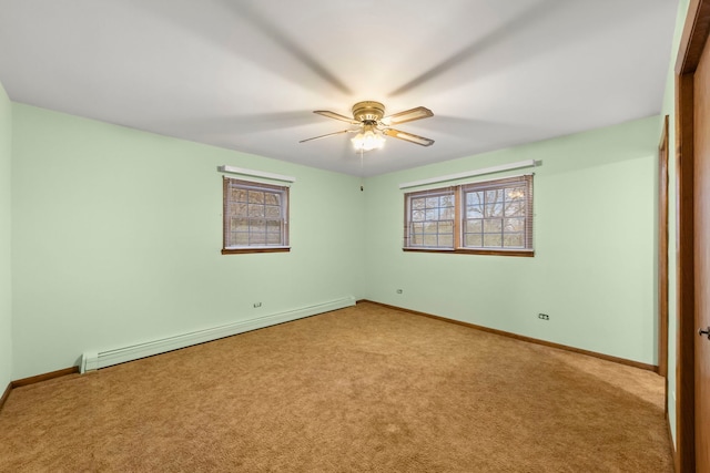 carpeted empty room with a wealth of natural light, ceiling fan, and a baseboard radiator