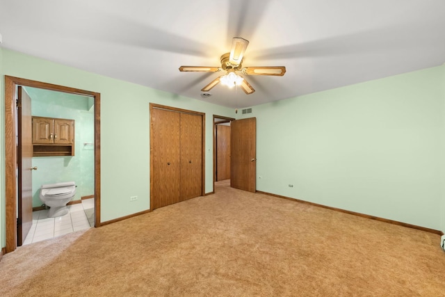 unfurnished bedroom featuring ensuite bathroom, ceiling fan, and light colored carpet