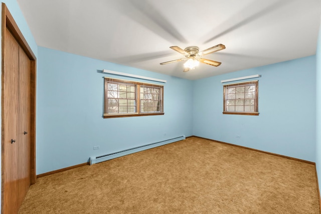 unfurnished bedroom featuring ceiling fan, light colored carpet, baseboard heating, and multiple windows