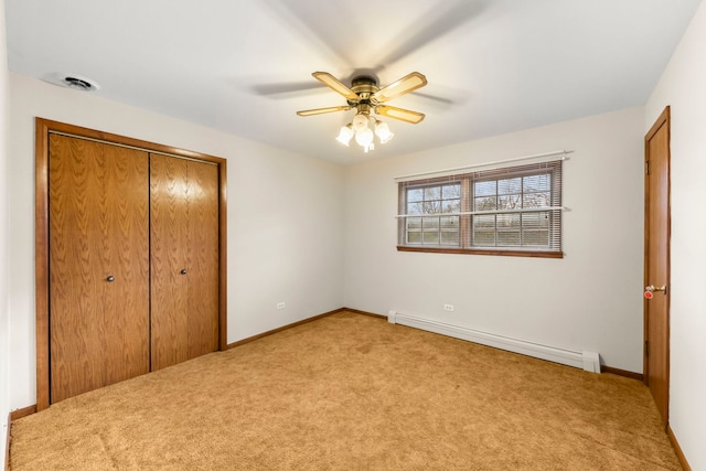 unfurnished bedroom featuring a closet, a baseboard radiator, ceiling fan, and light colored carpet