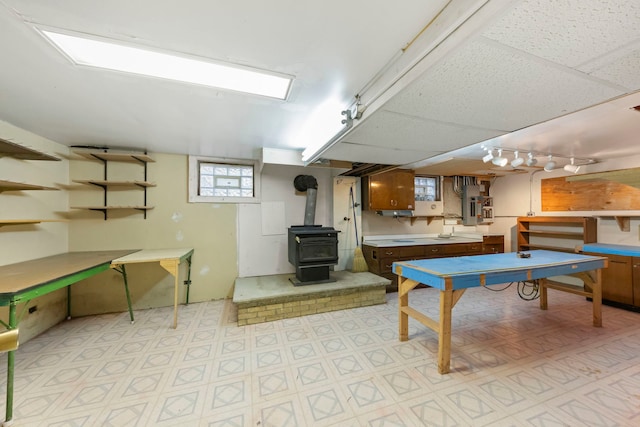 rec room featuring a paneled ceiling and a wood stove