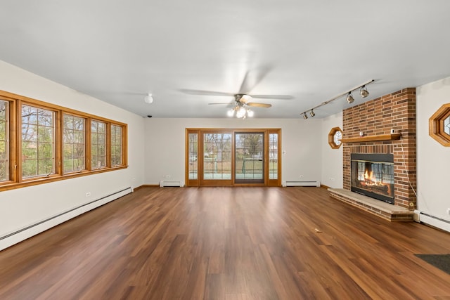 unfurnished living room with a brick fireplace, dark hardwood / wood-style floors, ceiling fan, and a baseboard radiator