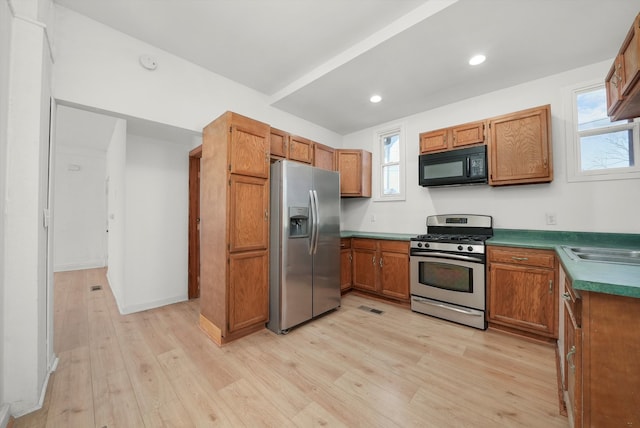 kitchen with sink, light hardwood / wood-style flooring, and appliances with stainless steel finishes