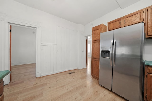 kitchen with light hardwood / wood-style floors and stainless steel refrigerator with ice dispenser