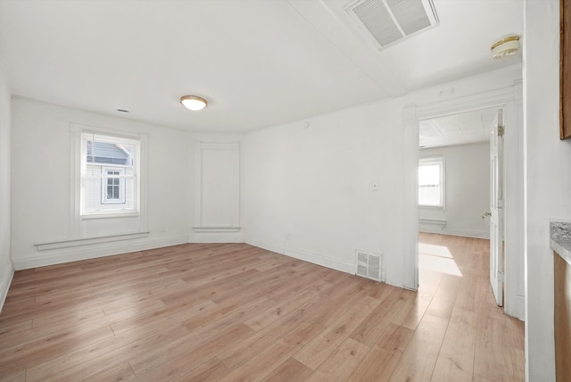 unfurnished room featuring a healthy amount of sunlight and light wood-type flooring