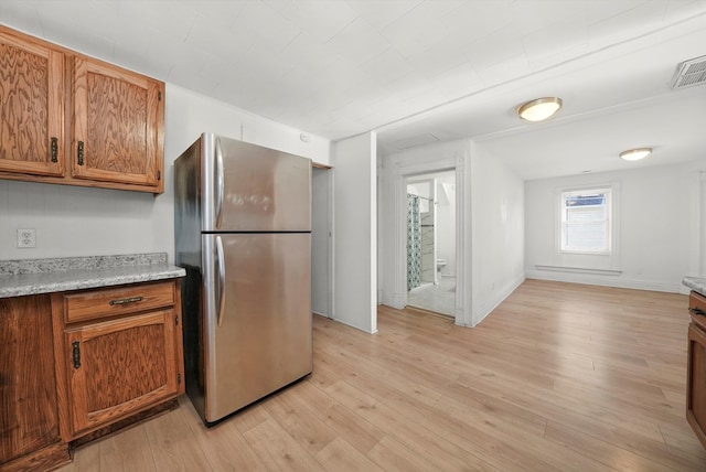 kitchen with stainless steel fridge and light wood-type flooring