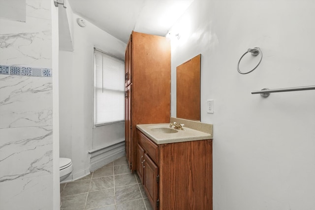 bathroom with tile patterned flooring, vanity, and toilet