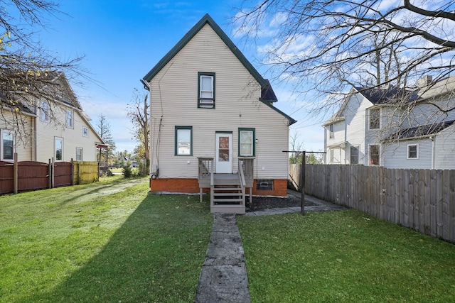 rear view of house featuring a yard