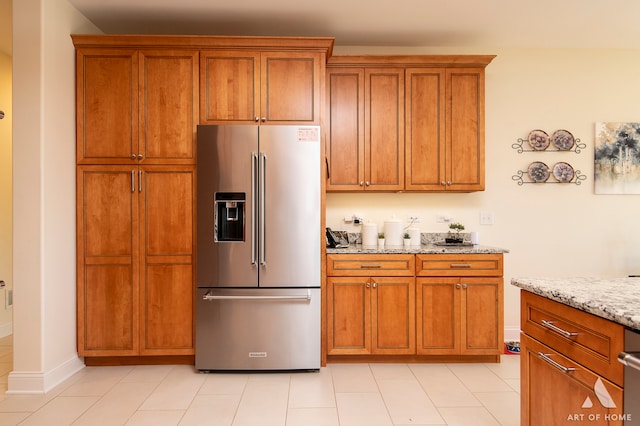 kitchen featuring high end refrigerator and light stone counters