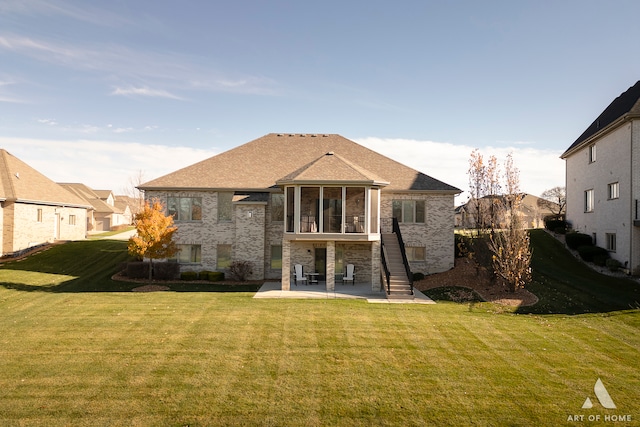 rear view of property featuring a lawn, a sunroom, and a patio