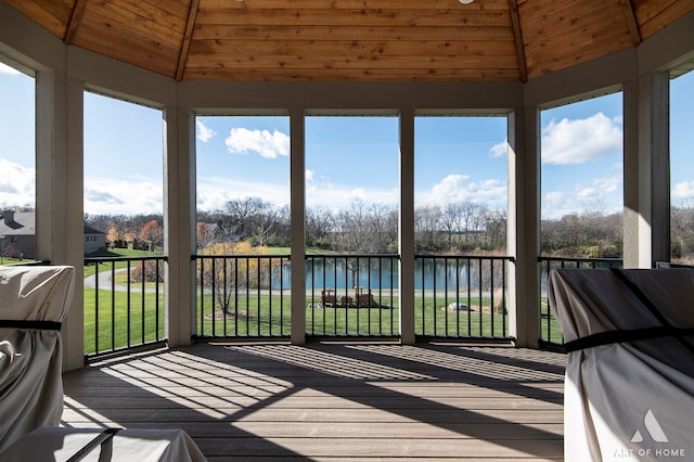 sunroom / solarium featuring a water view, wood ceiling, and vaulted ceiling