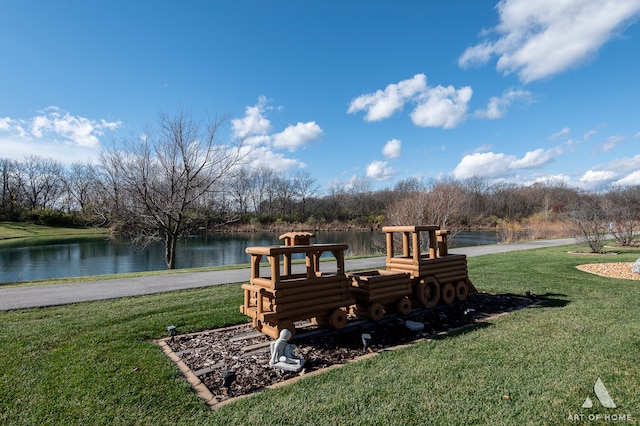 view of playground featuring a lawn and a water view