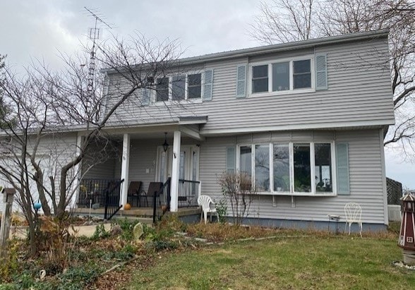 front of property featuring covered porch and a front lawn