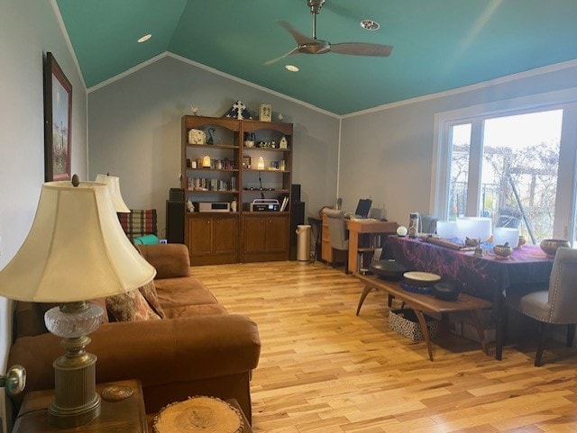 living room with ceiling fan, vaulted ceiling, ornamental molding, and light hardwood / wood-style flooring