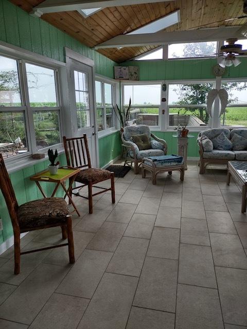 1522 E 7th Rd, Lostant, IL 61334 - sunroom with lofted ceiling with skylight, an outdoor living space, wooden ceiling, and plenty of natural light