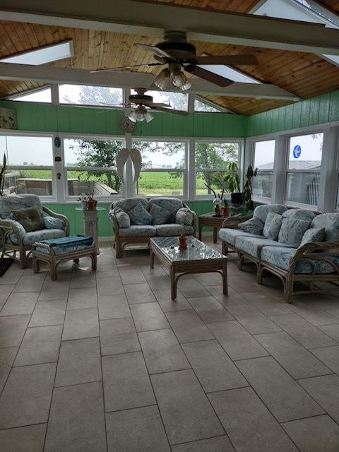 1522 E 7th Rd, Lostant, IL 61334 - sunroom with tile patterned floors, vaulted ceiling with beams, a ceiling fan, and outdoor lounge area