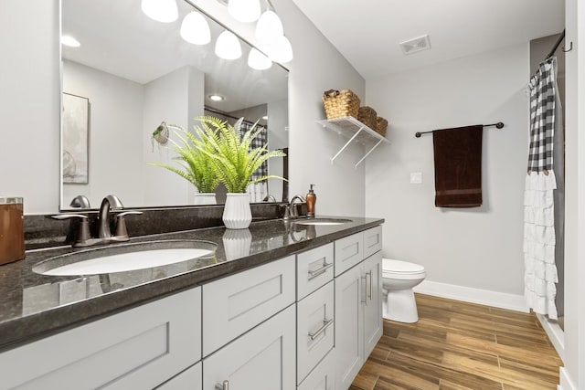 bathroom featuring toilet, vanity, and hardwood / wood-style flooring