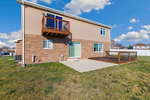 rear view of property with central air condition unit, a patio area, a balcony, and a yard