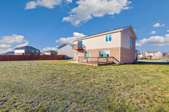 rear view of property with a balcony and a lawn