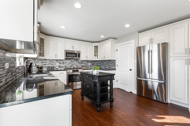 kitchen with white cabinets, stainless steel appliances, a kitchen island, and sink