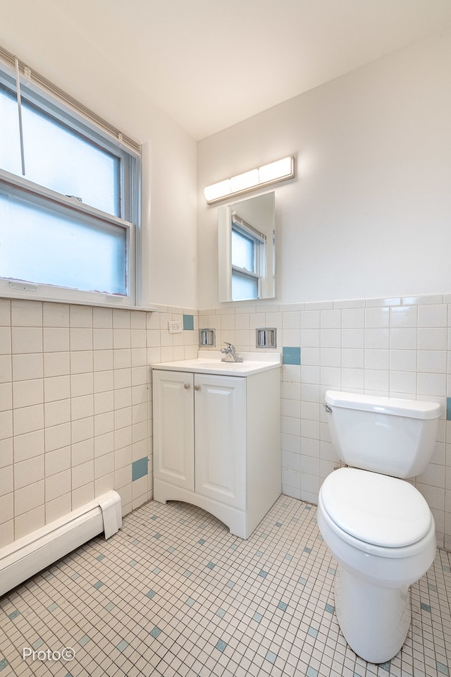 bathroom with tile patterned floors, vanity, a healthy amount of sunlight, and tile walls