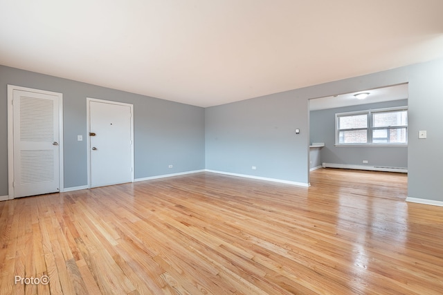 spare room with light wood-type flooring and baseboard heating