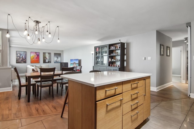 kitchen with wood-type flooring, a center island, an inviting chandelier, and a breakfast bar area