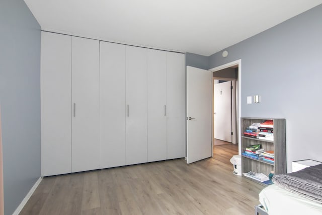 unfurnished bedroom featuring light wood-type flooring and a closet