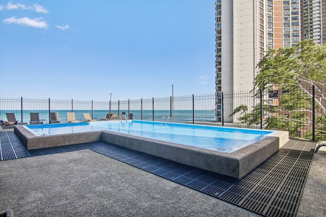 view of swimming pool with a water view