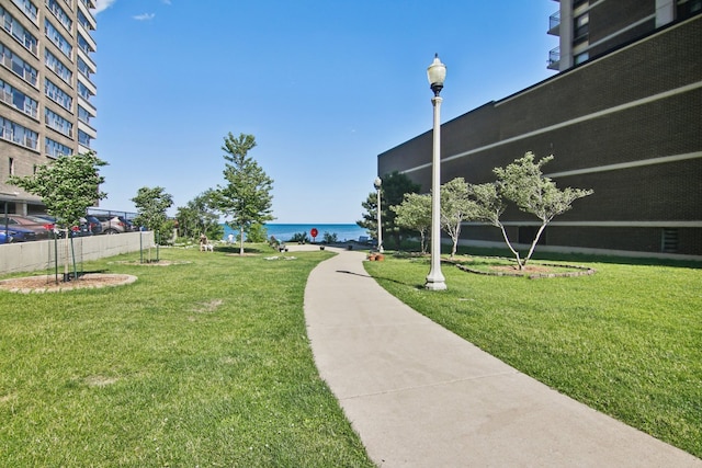 view of home's community with a lawn and a water view