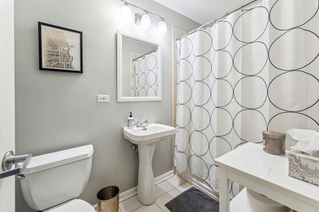 bathroom featuring tile patterned flooring, toilet, and walk in shower