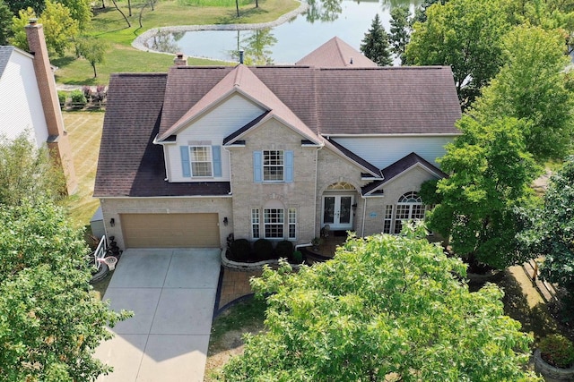 view of front of property featuring a garage, a water view, and french doors