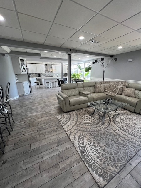 living room featuring a paneled ceiling