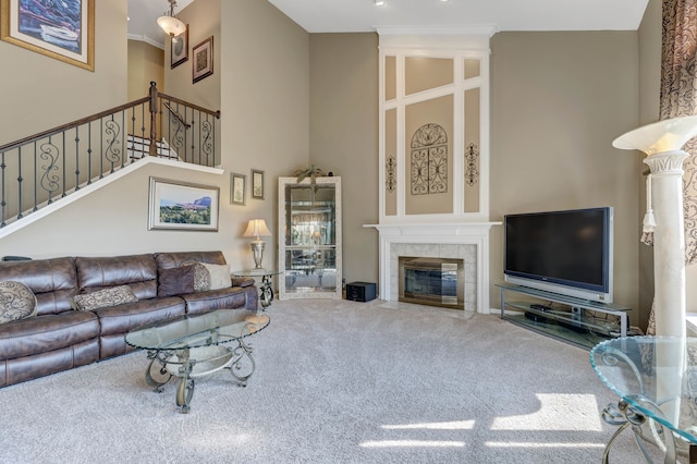 carpeted living room with a tiled fireplace and a towering ceiling