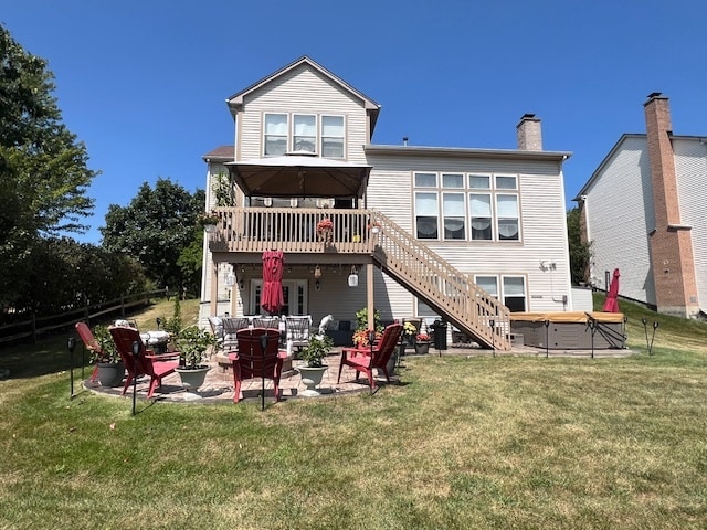 back of house with a lawn, a patio, and a hot tub