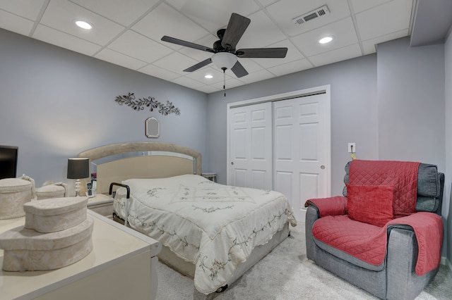 bedroom featuring carpet flooring, a paneled ceiling, ceiling fan, and a closet