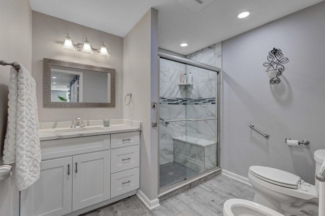 bathroom with vanity, a bidet, toilet, and walk in shower