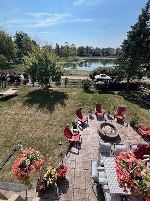 view of yard featuring a patio, a water view, and a fire pit