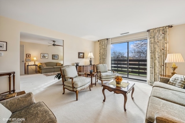 carpeted living room with ceiling fan