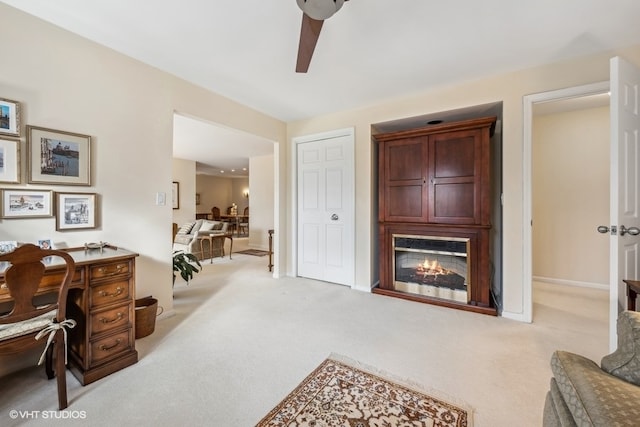 carpeted home office featuring ceiling fan