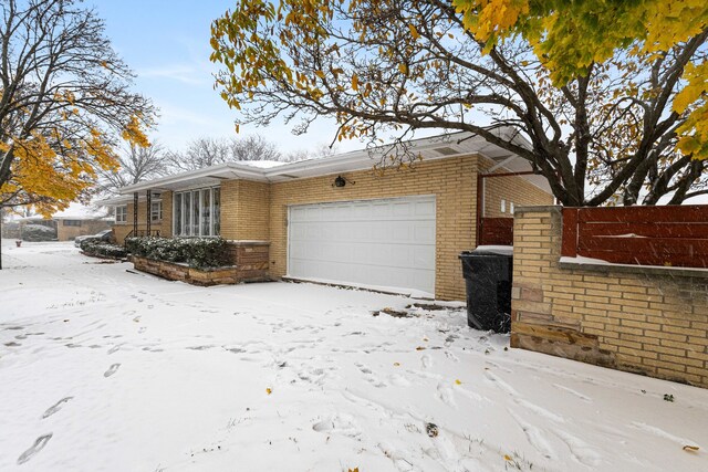 view of snowy exterior with a garage