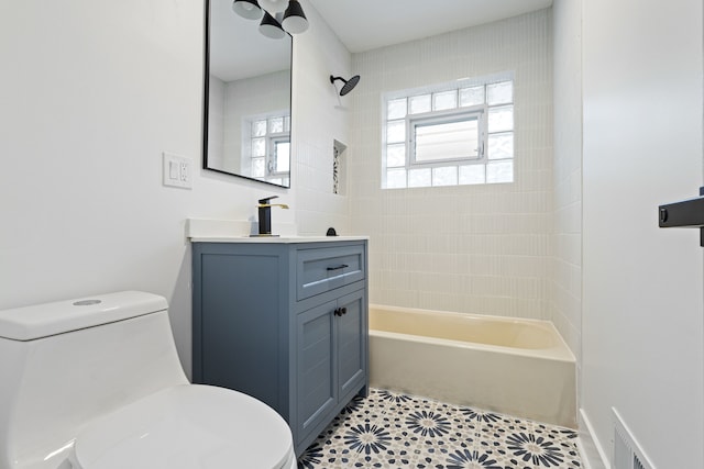 full bathroom with vanity, tiled shower / bath combo, toilet, and tile patterned flooring